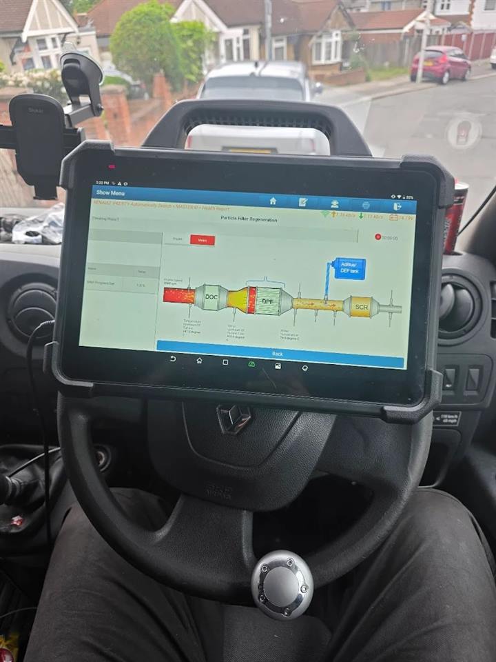 Diagnostic tablet mounted on a Renault van's steering wheel running a diesel particulate filter regeneration