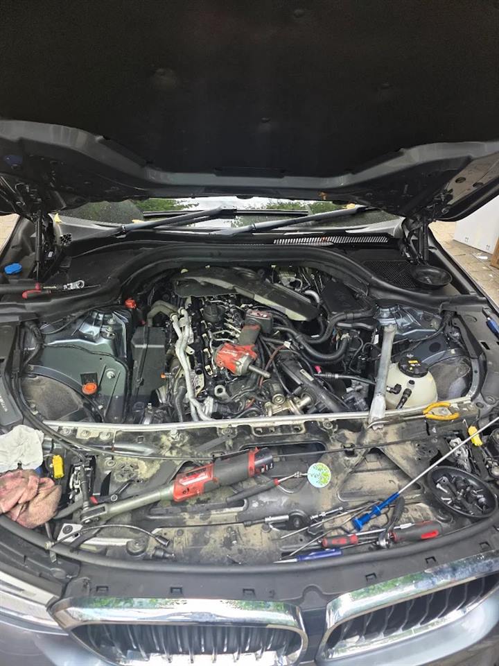 BMW engine bay opened up with tools laid across the slam panel